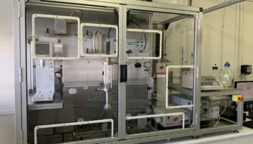 Overview of the custom-built 120 bar high-pressure sapphire column test bench by IRIAN MECATRONICS, showing the complete system within its safety enclosure, used for gas hydrate research.