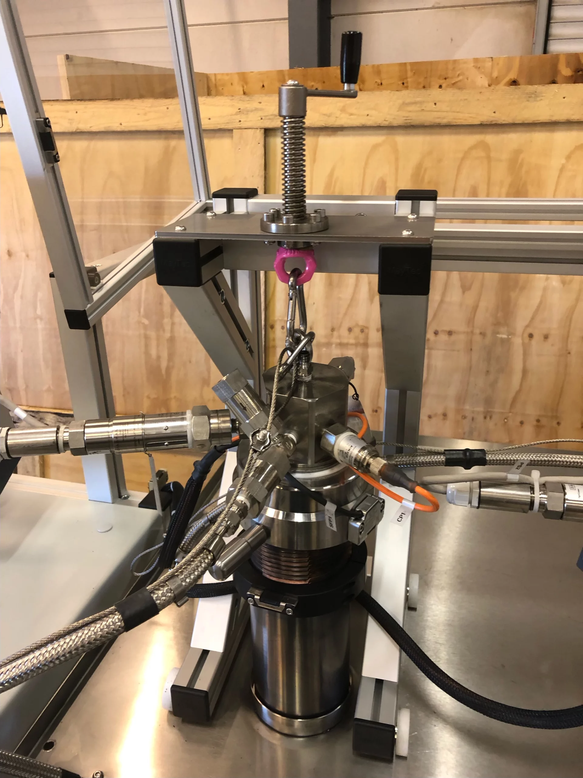 Tête de pompe sur mesure pour injection de fluides complexes. Gros plan sur la tête de pompe instrumentée d'une double seringue HPHT, conçue par IRIAN MECATRONICS pour le mélange de fluides sensibles.
