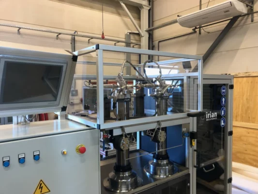 Gros plan sur les têtes de pompe à double seringue HPHT, montrant la tuyauterie inox et le capot de protection, conçues par IRIAN MECATRONICS.